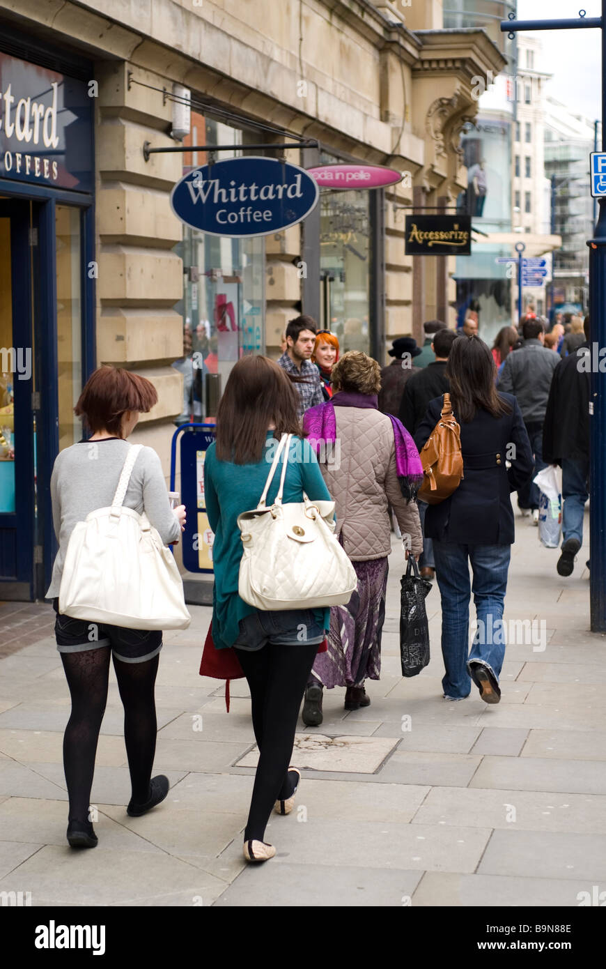 People walking on sidewalk in Manchester city centre UK Stock Photo