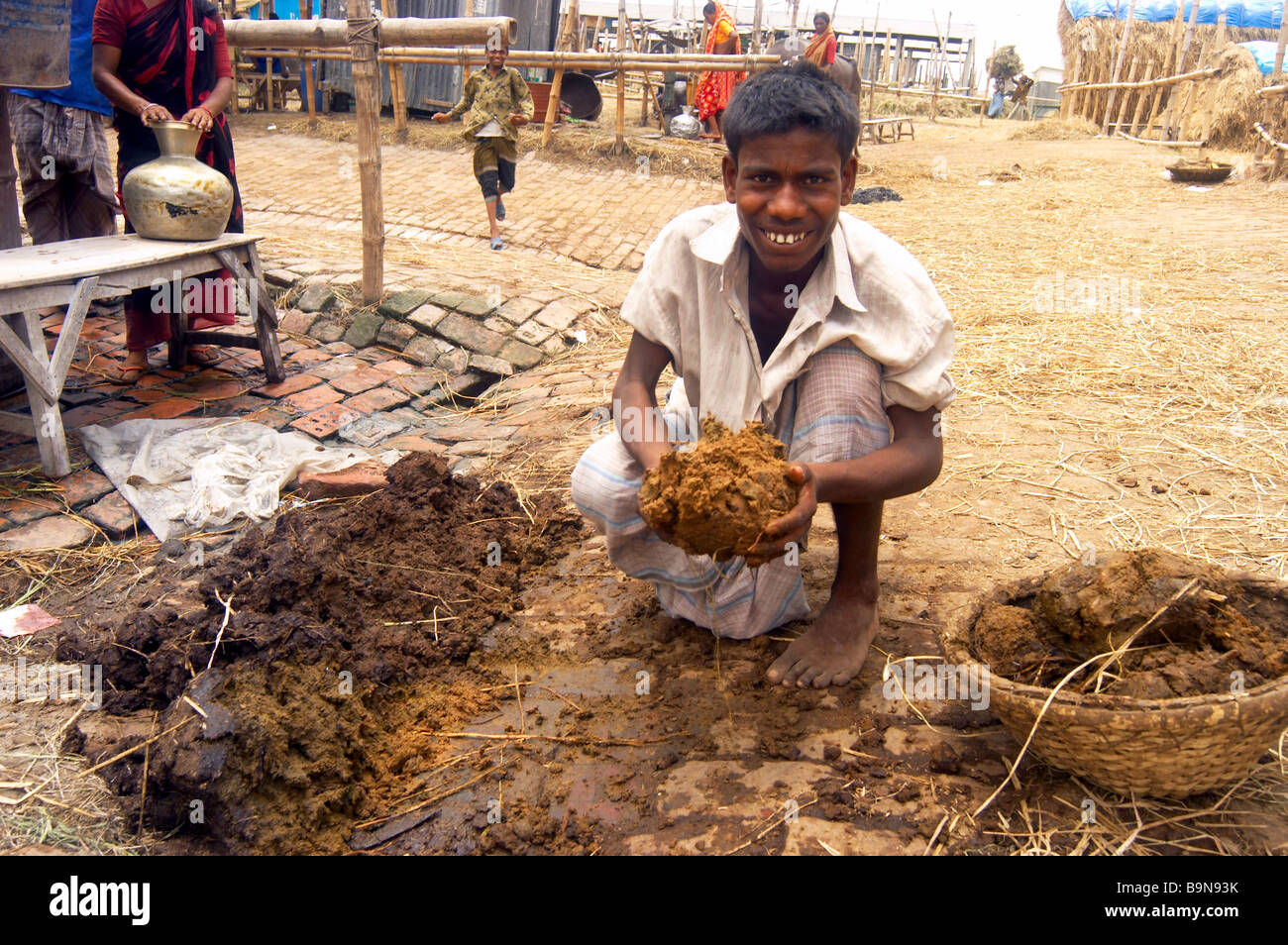 Boy packing cow dung child labor poverty hard work Stock Photo