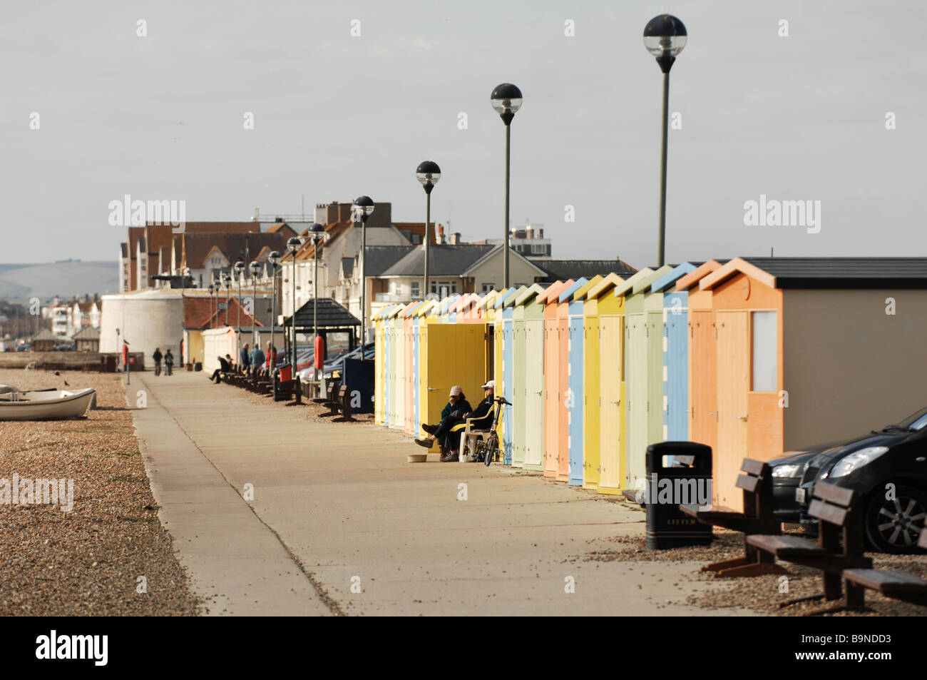 A couple huddled up at their beach hut in Seaford East Sussex UK Stock Photo