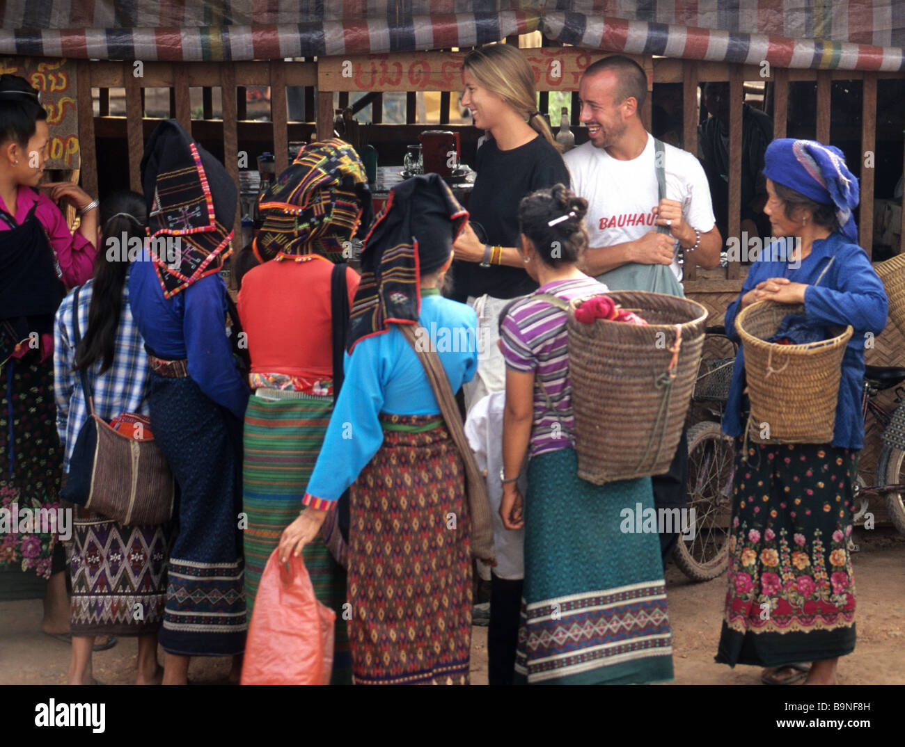 Tourists drawing the attention of street sellers, Muang Sing, north Laos. Stock Photo