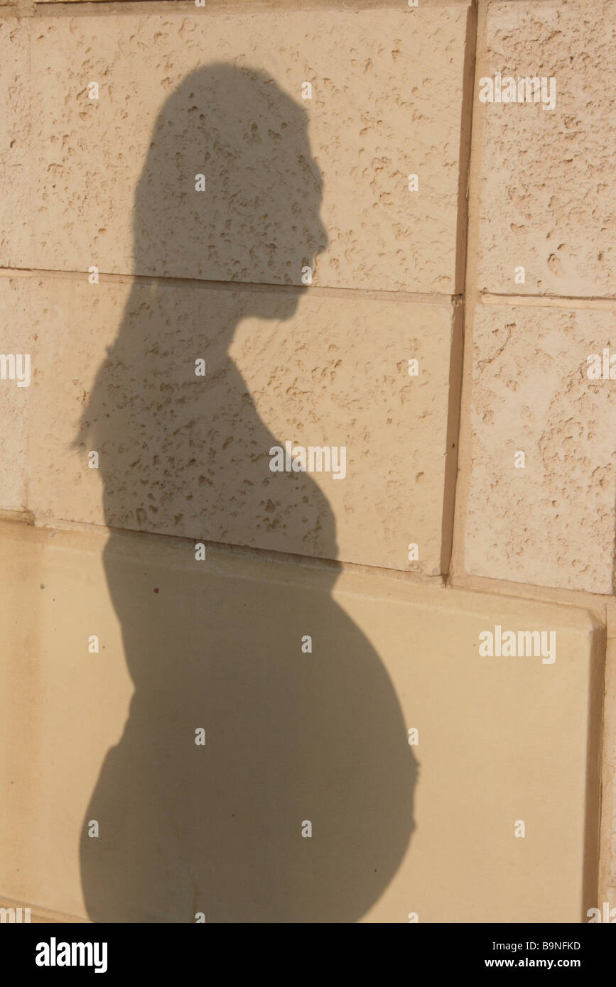Shadow on a wall of a 9 months Pregnant woman in her 30s standing outdoors Model release available Stock Photo