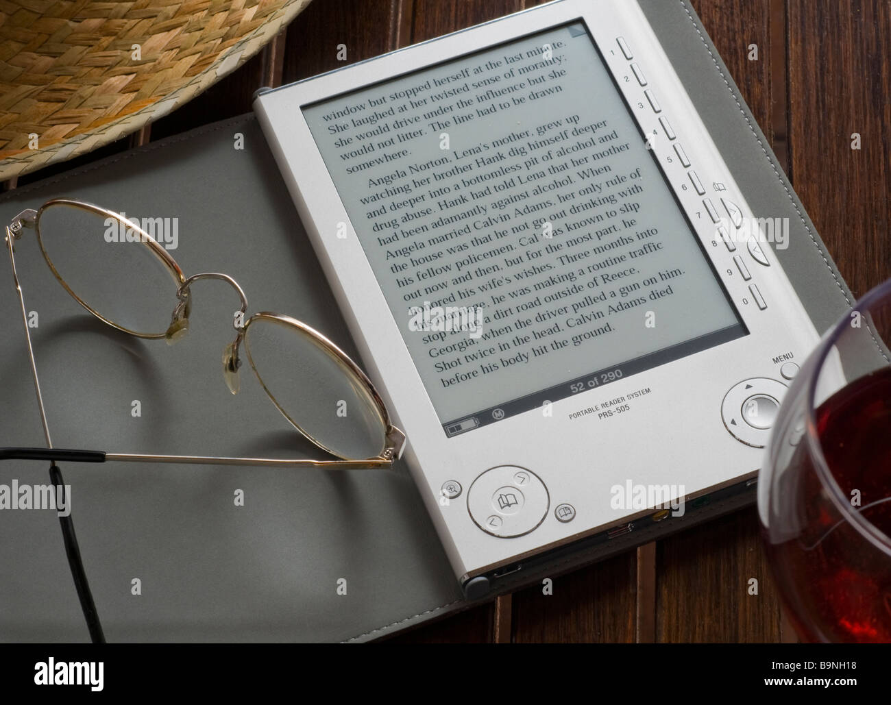 Sony e-Reader 2008 ,first generation  a digital electronic portable book storage and reading device on table with drink straw hat and glasses Stock Photo