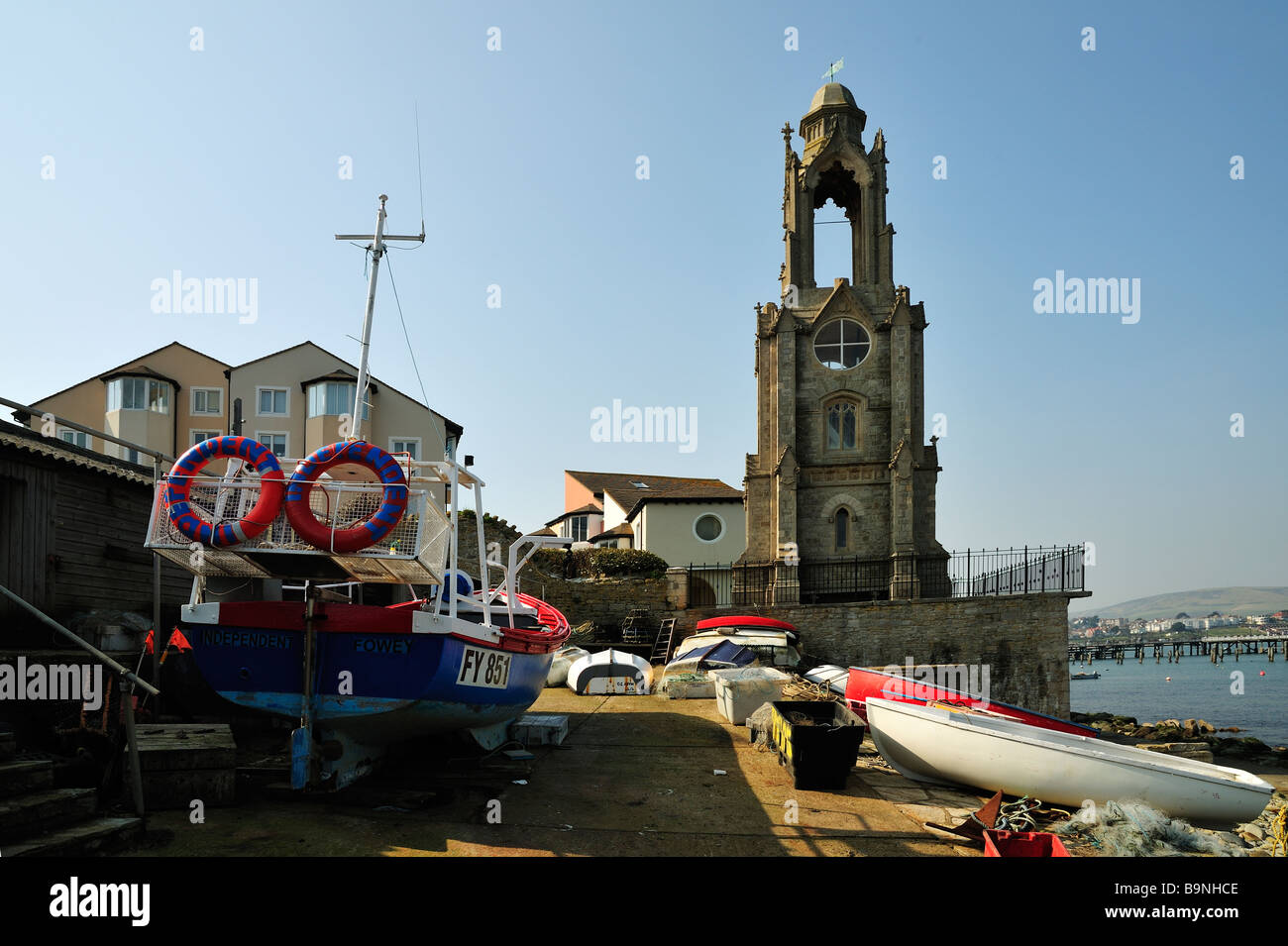 SWANAGE, DORSET, UK - MARCH 21, 2009:  Boats pulled up on the beach in front of the Wellington Clock Stock Photo