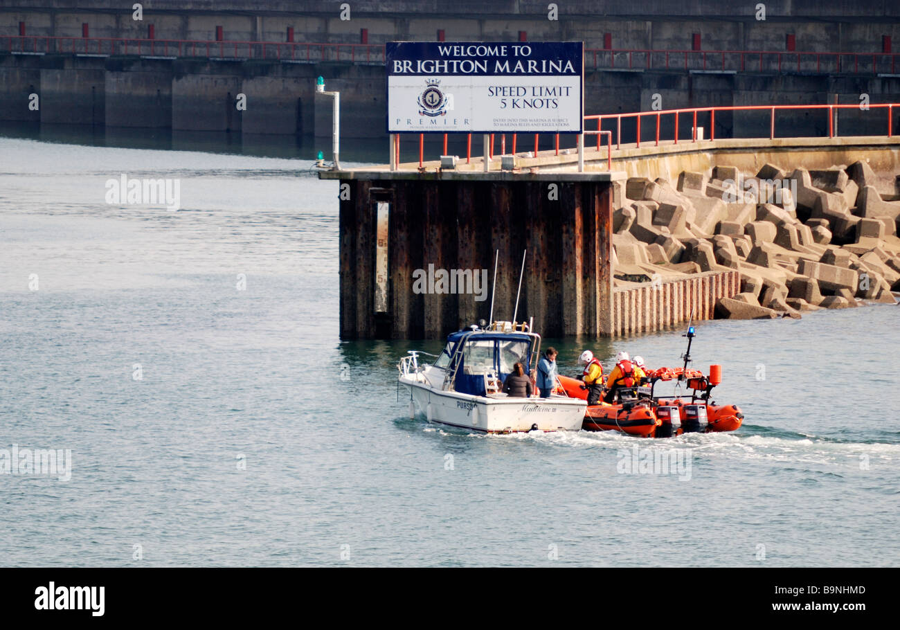 RNLI lifeboat tows stricken boat into Brighton Marina Stock Photo