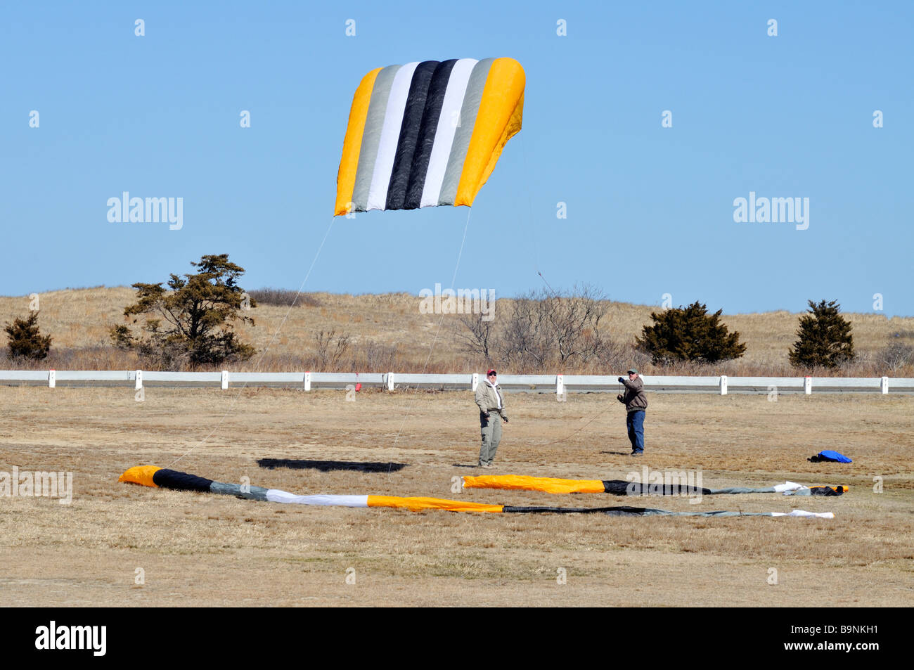 2 two men launching a large [sled kite] to fly Stock Photo