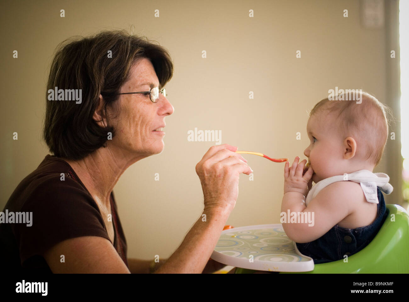 Grandma feeding baby Stock Photo