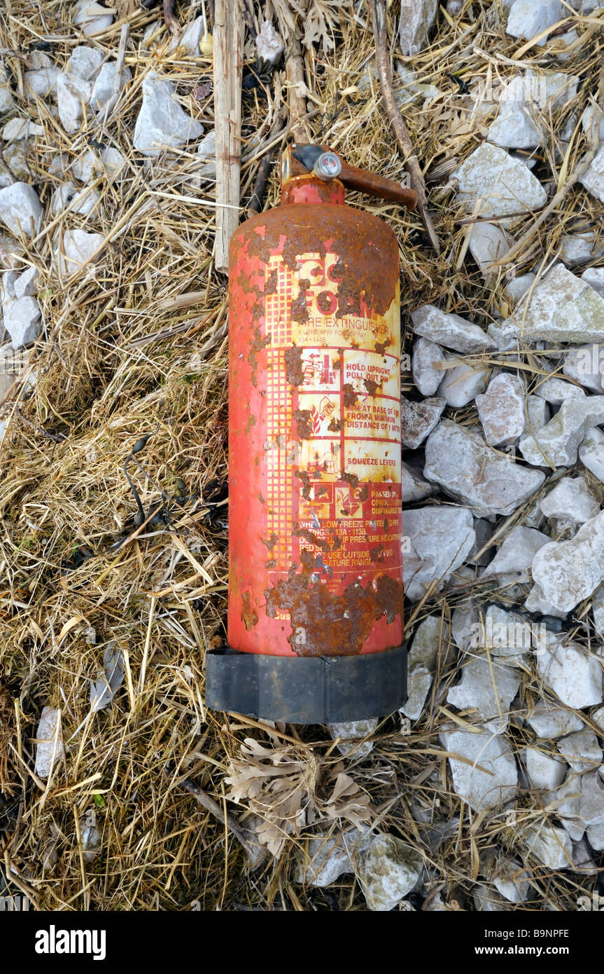 A fire extinguisher washed up on a beach strandline Stock Photo