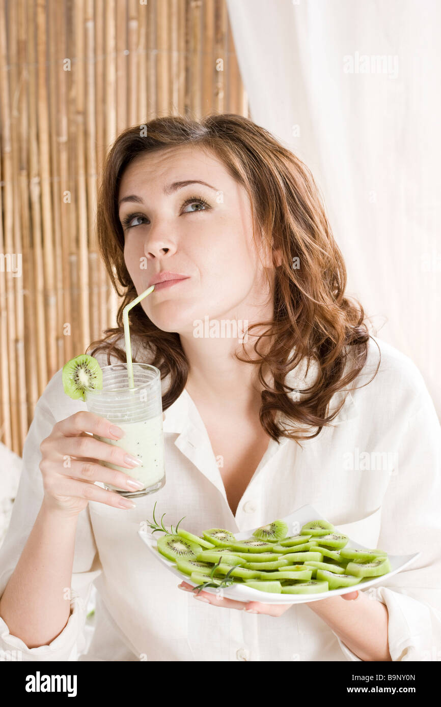 woman drinking kiwi milkshake Stock Photo