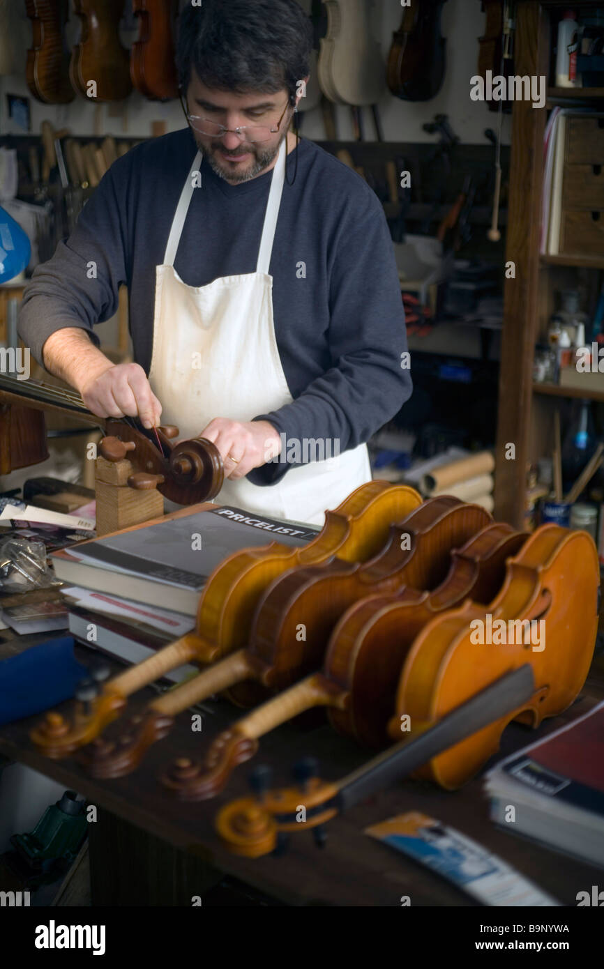 A craftsman repairing a viola in his shop on Via Della Bella Arte Bologna Italy Stock Photo