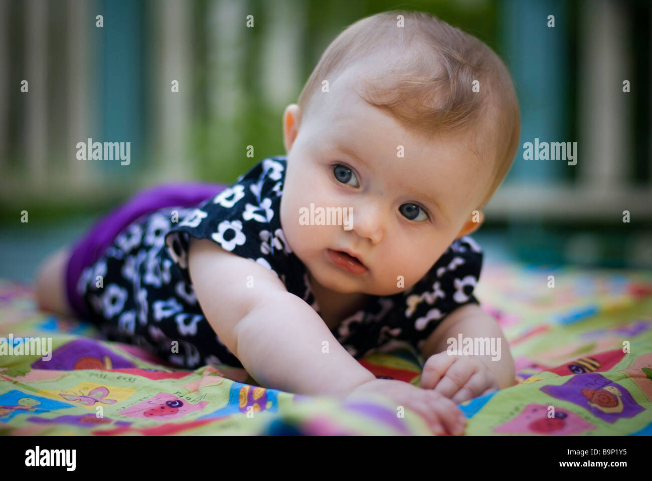 Baby girl lying in cot Stock Photo