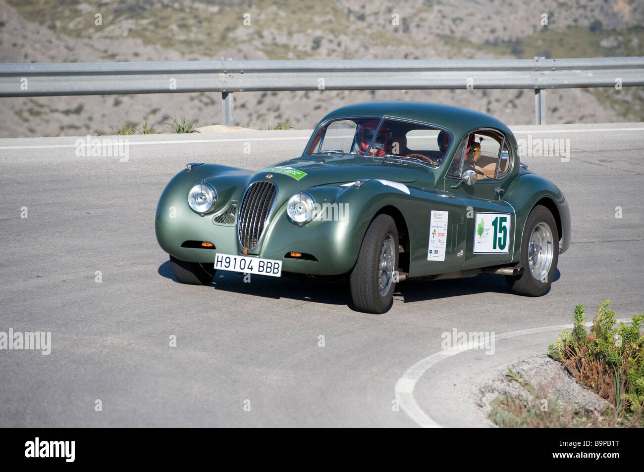 Green 1954 Jaguar XK140 sports car racing in the Classic car rally