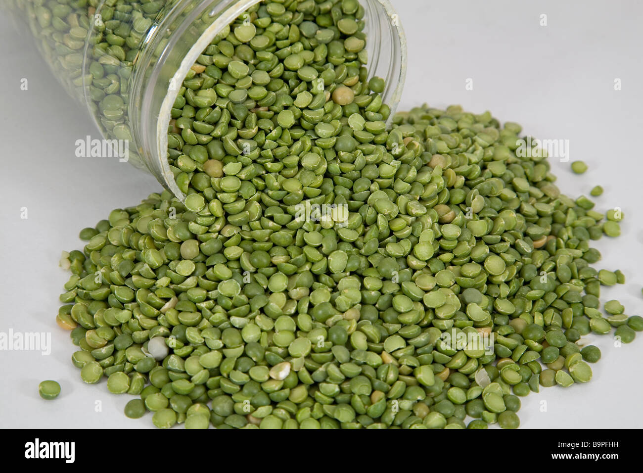 Split green peas lentils legume being stored in a jar Stock Photo