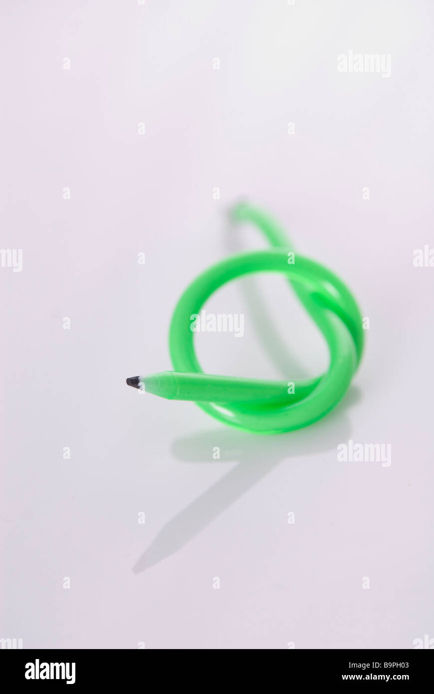 Green flexible pencil with a knot on a white background Stock Photo