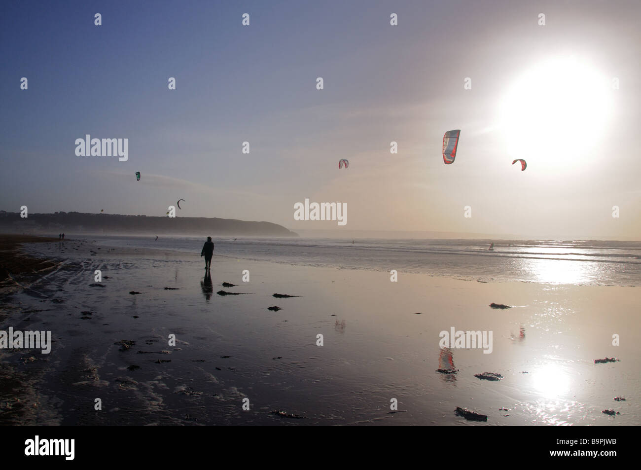 Kite surfers against the evening sun Stock Photo
