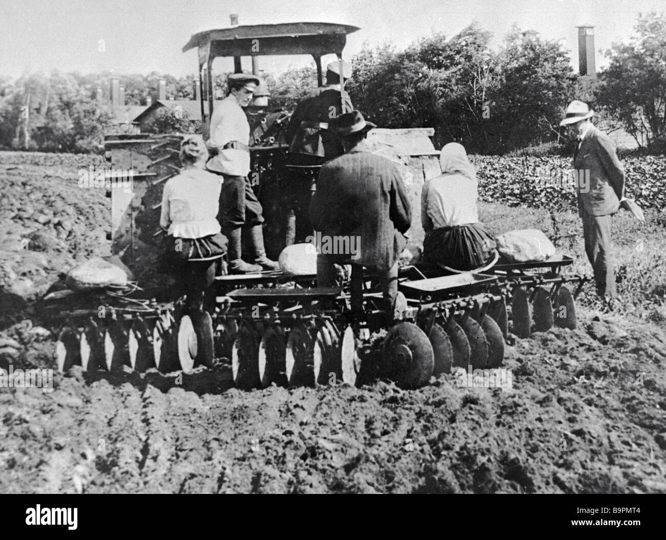 Collective farmers cultivating land before planting potatoes Stock ...