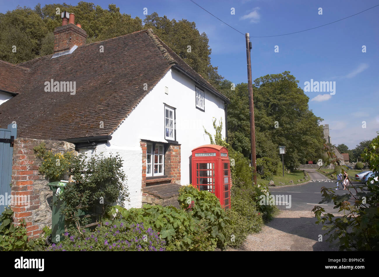 A village phonebox by a white cottage Stock Photo