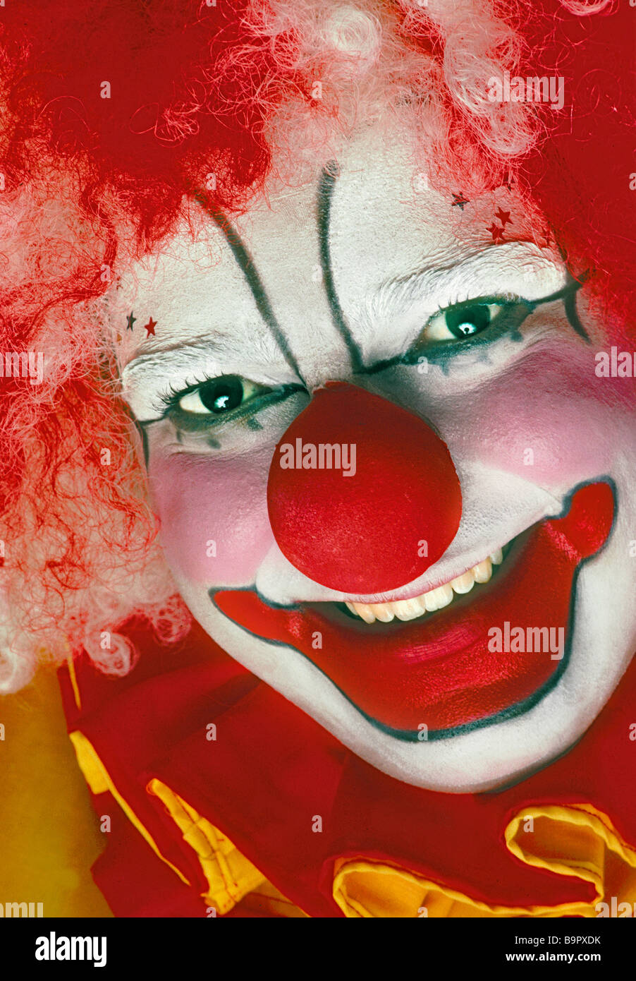 Funny, smiling clown wearing makeup and red wig with red nose Stock ...