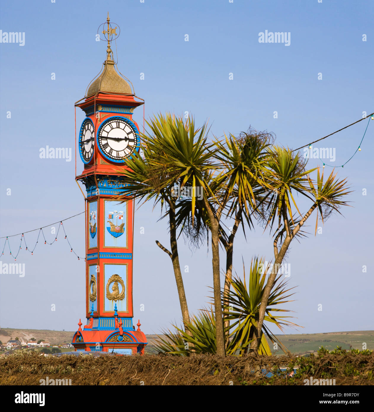 A view of the iconic Jubilee clock and trees long the seafront at Weymouth, Dorset. UK. Stock Photo