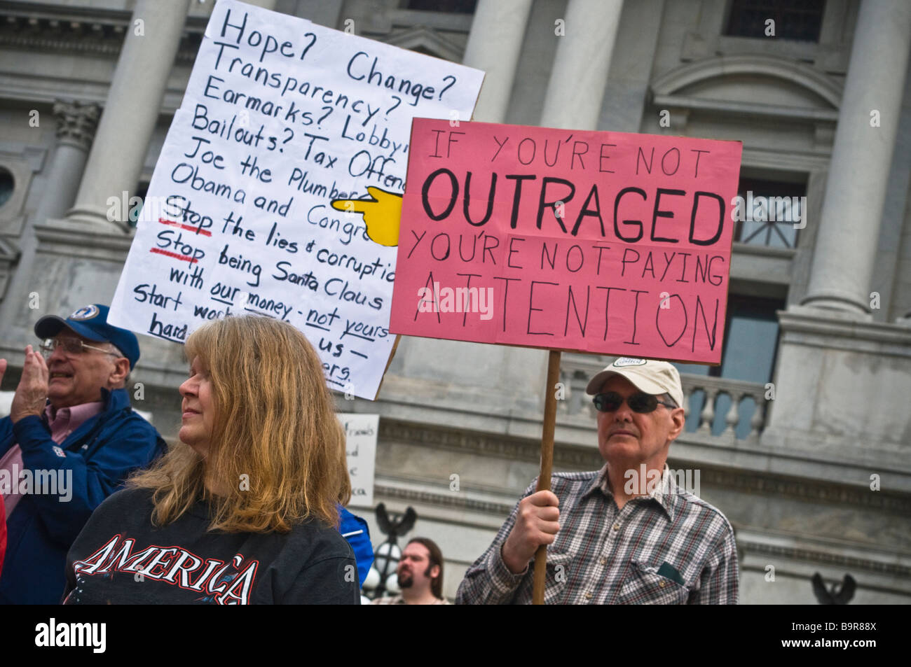 anti spending tax protest tea party Harrisburg PA , demonstrator, If you're not outraged you're not paying attention sign USA Stock Photo