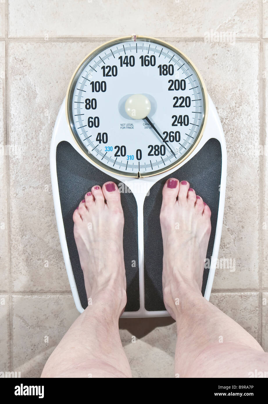 Woman in bare feet and legs standing on scale reading 270 lbs Stock Photo Alamy