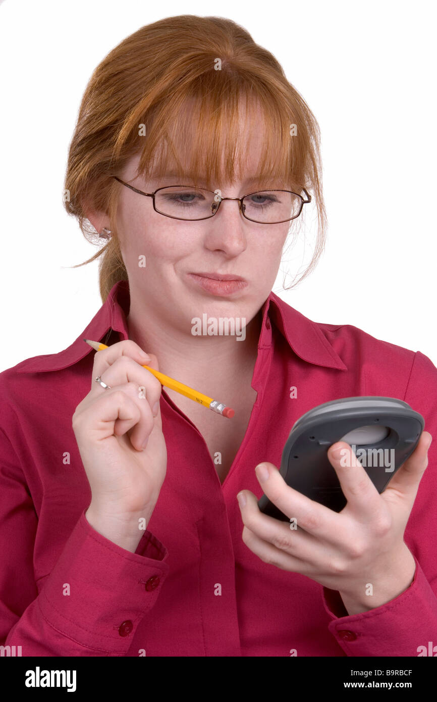 A woman punching calculator buttons with a pencil Stock Photo