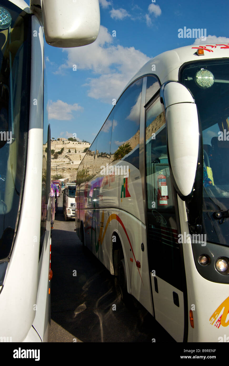 Tight squeeze for steady stream of tour buses outside walls of old Jerusalem city Stock Photo
