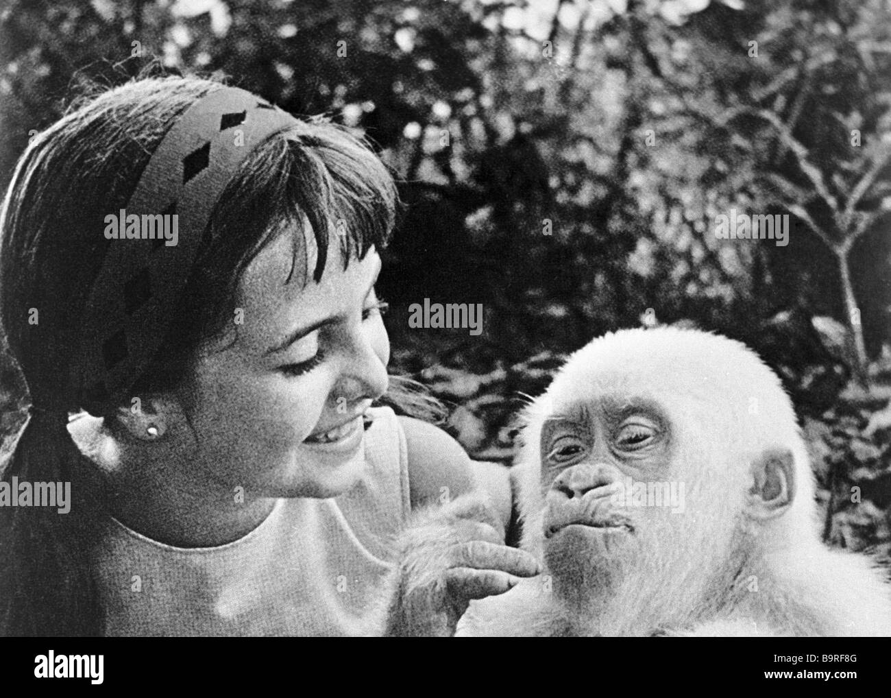 A girl playing with an albino monkey in the Barcelona Zoo Stock Photo