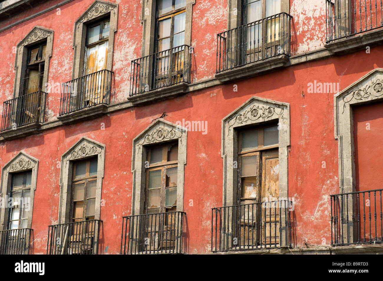 Arched windows on a red wall in the Centro Historico, Mexico City Stock Photo