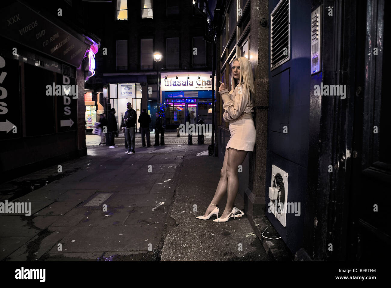 Working girl stands outside Soho London sex shop / strip joint Stock Photo  image