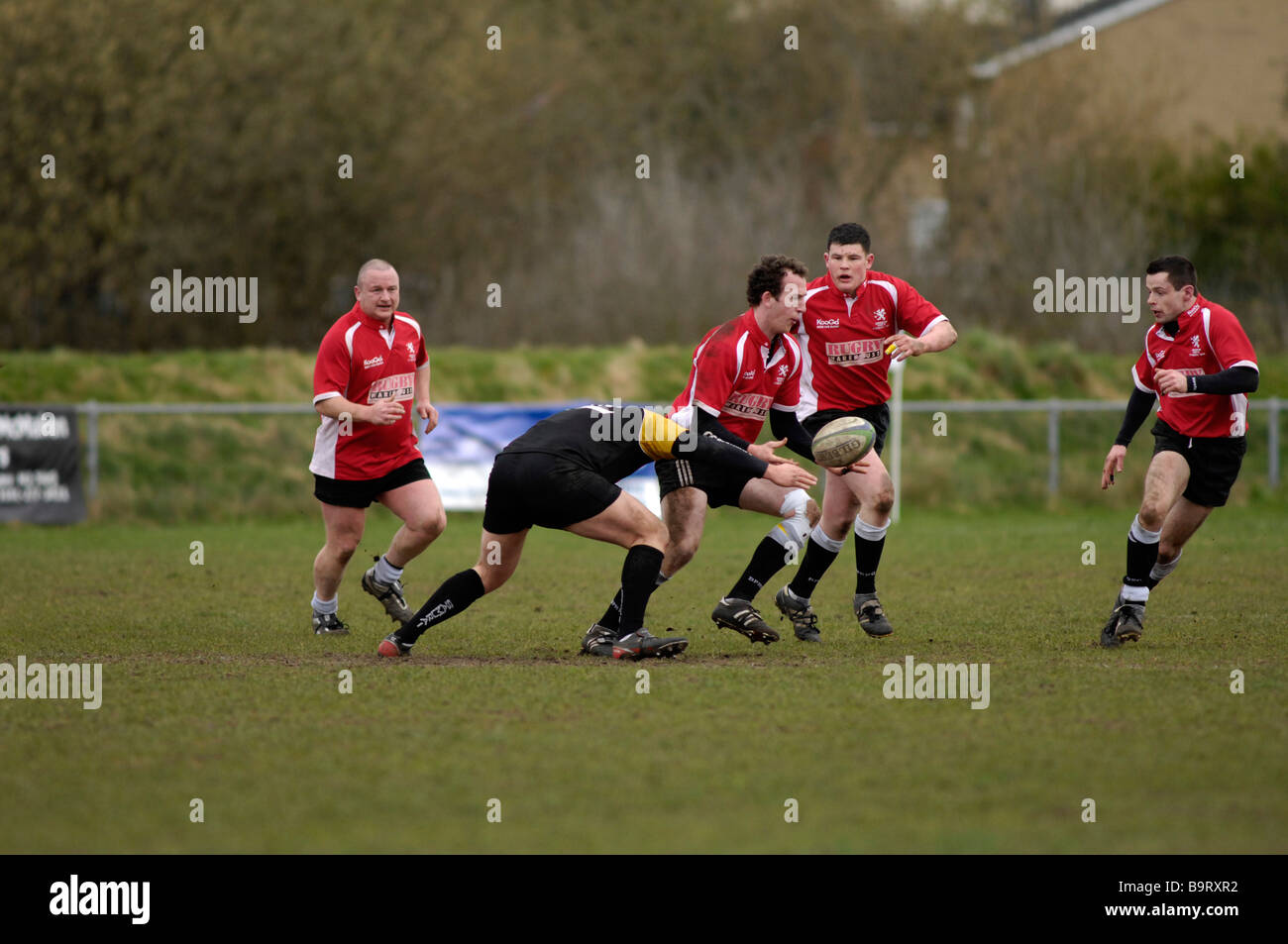 rugby player passing the ball as he is tackled Stock Photo