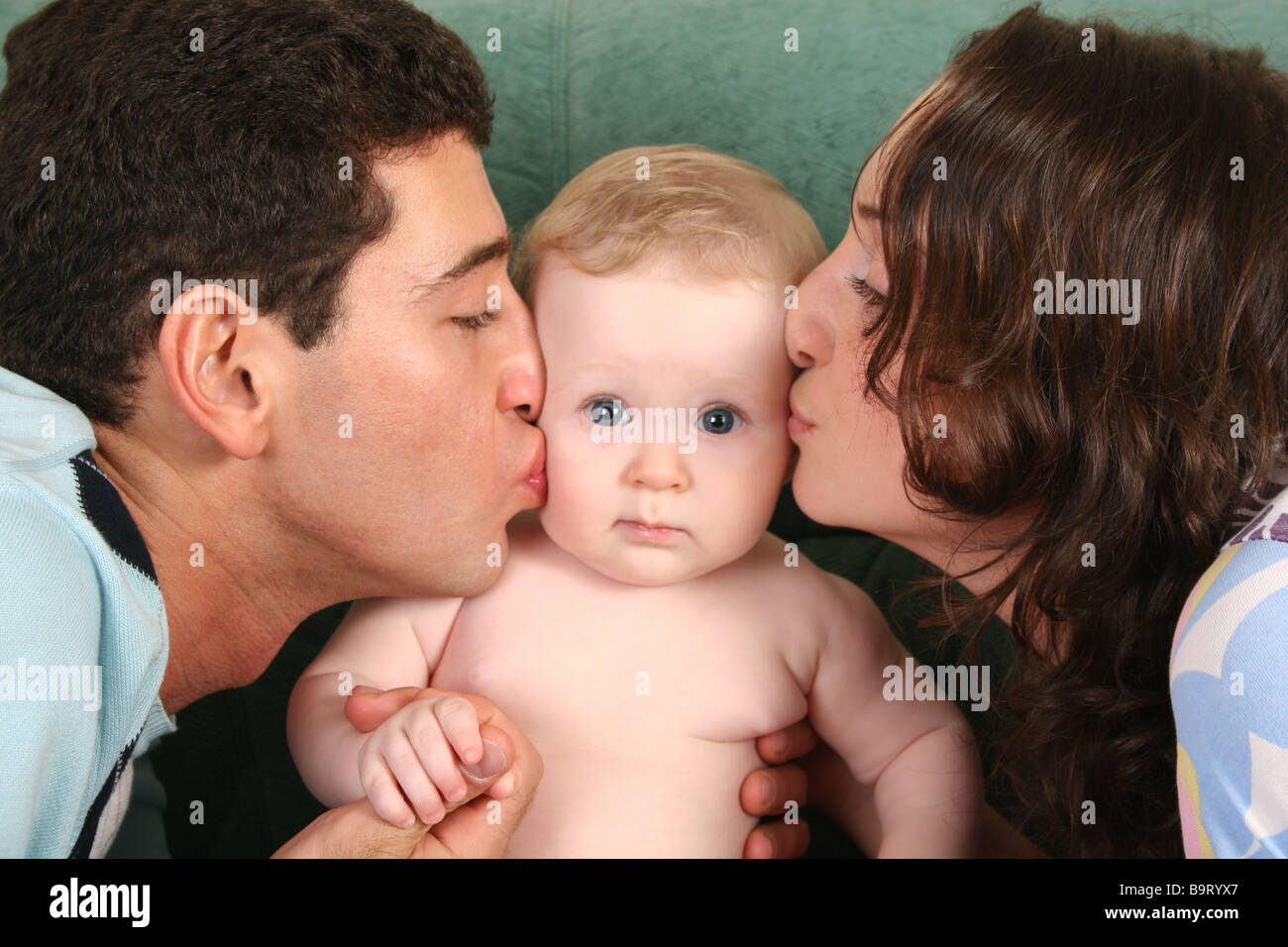 Мама папа поцелуй. Родители целуют ребенка. Мама и папа целуют ребенка. Отец целует ребенка. Фото родителей целующих детей.