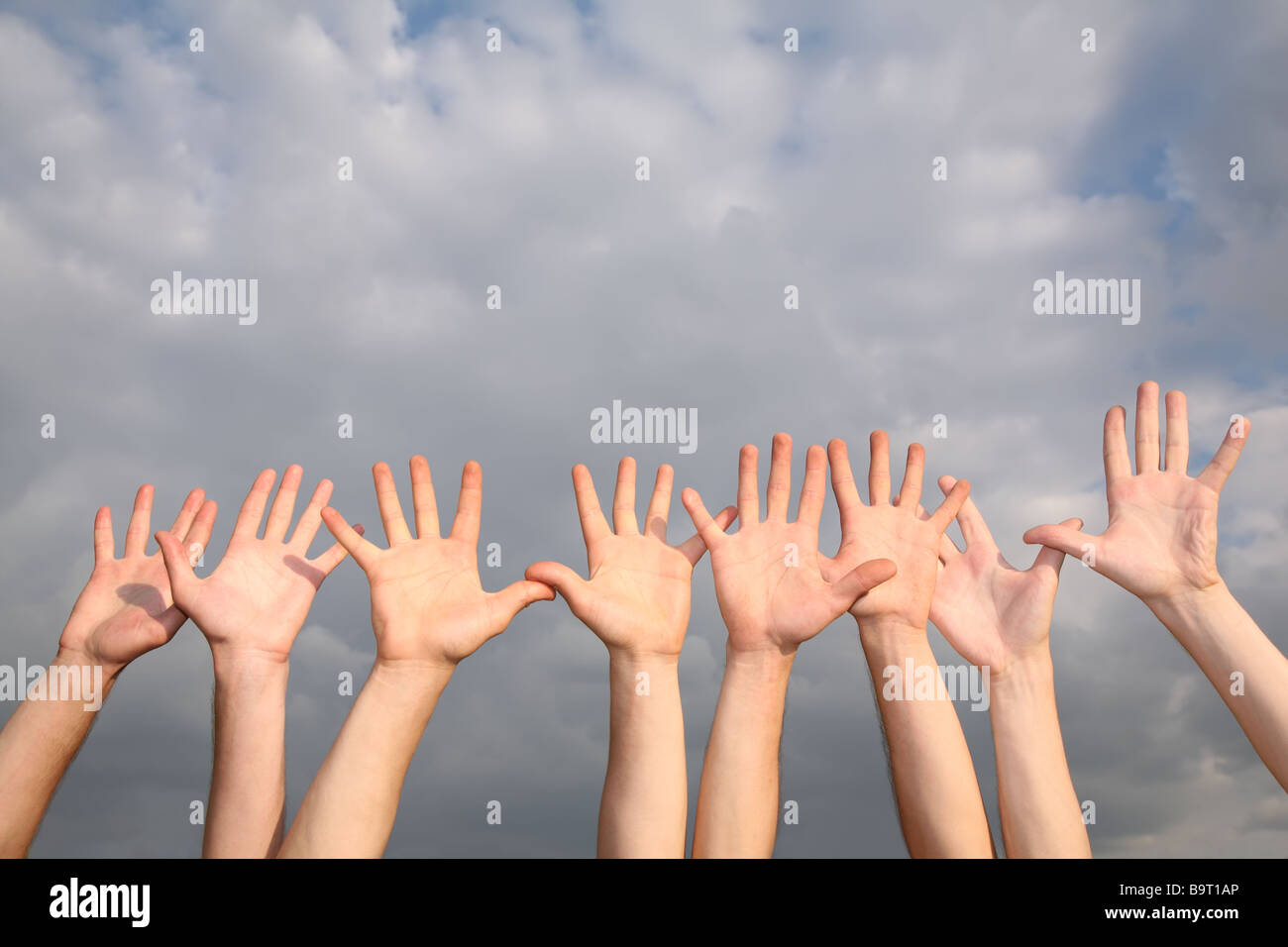 raised hands on cloudy sky background 2 Stock Photo - Alamy