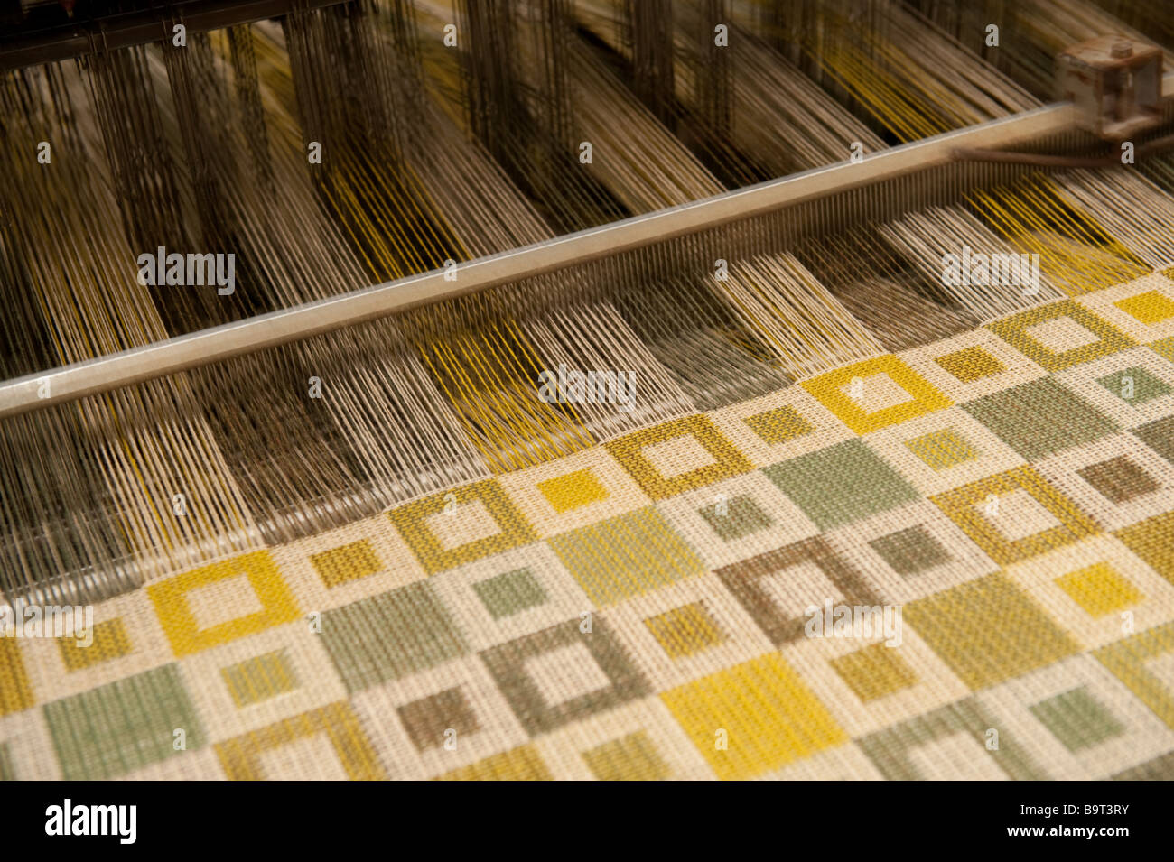 Woven fabric emerging from the loom at Melin Tregwynt welsh woollen mill Castlemorris Pembrokeshire wales UK Stock Photo