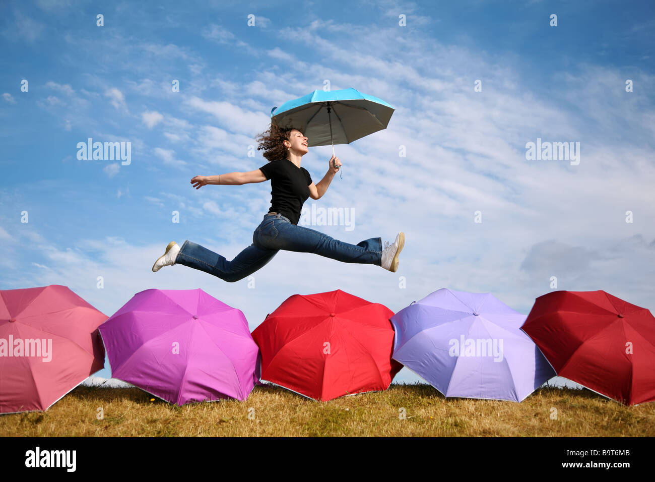young woman jumps with the umbrella above the umbrellas Stock Photo - Alamy