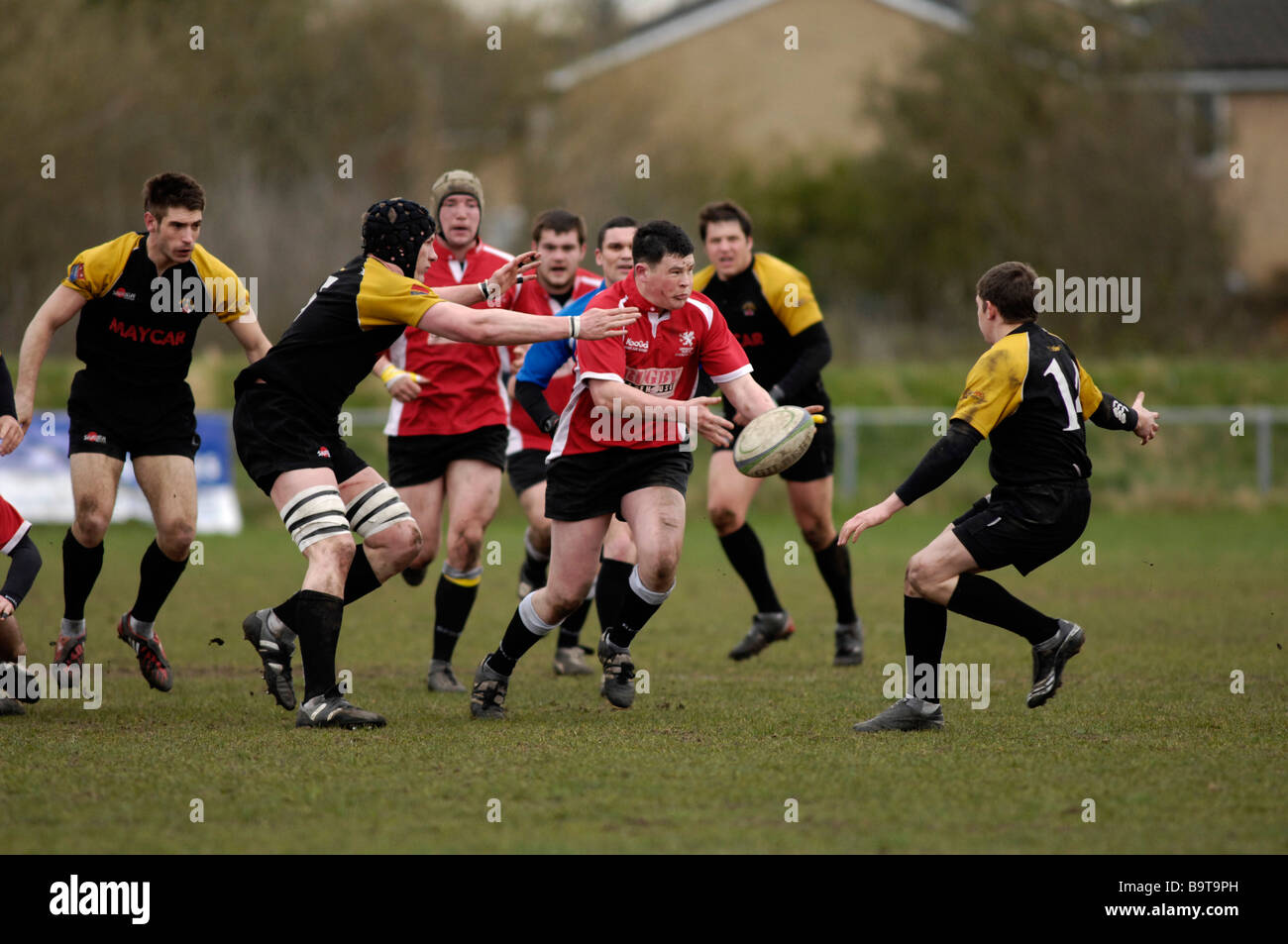 rugby player passing the ball as he is about to be tackled Stock Photo