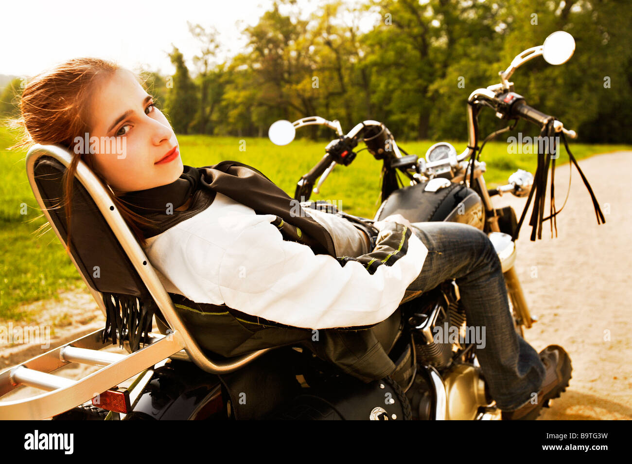 Young Woman relaxing on the motorbike Stock Photo