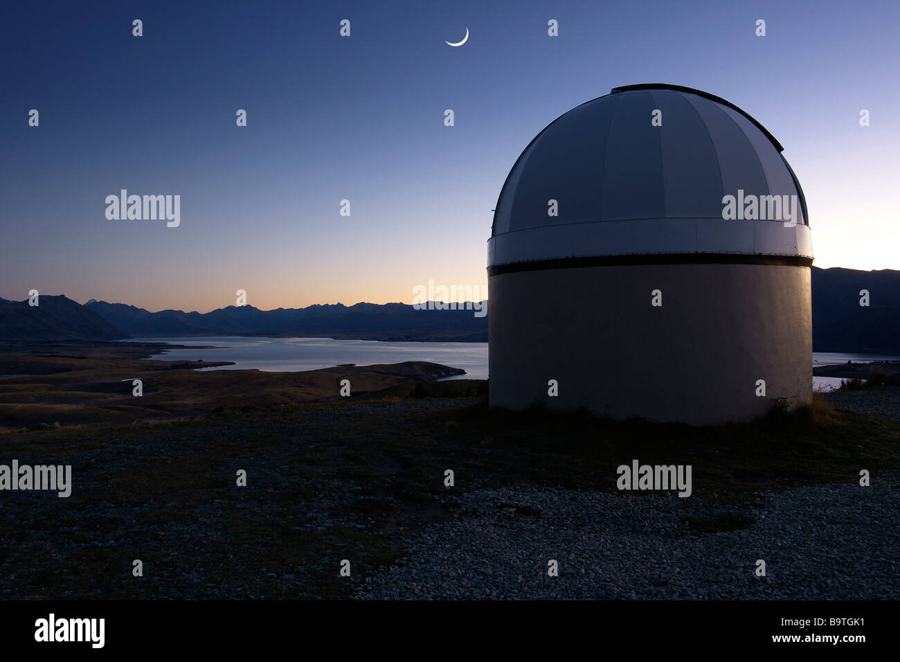 Mt John Observatory and moon crescent at Dawn at Lake Tekapo, New Zealand. Stock Photo