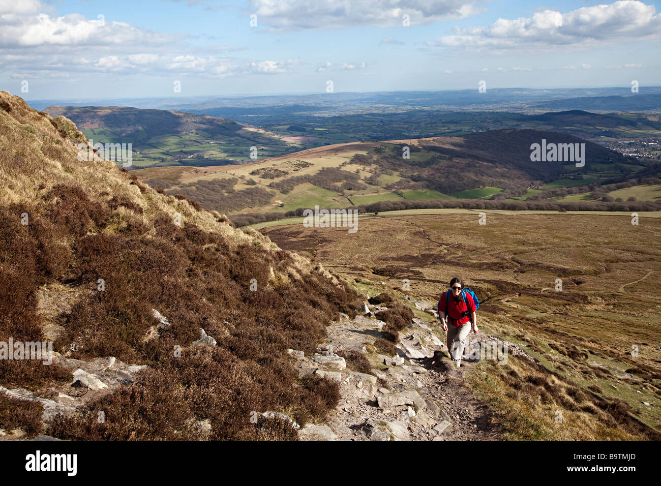 Female backpacker climbing footpath on Sugarloaf mountain Wales UK Stock Photo