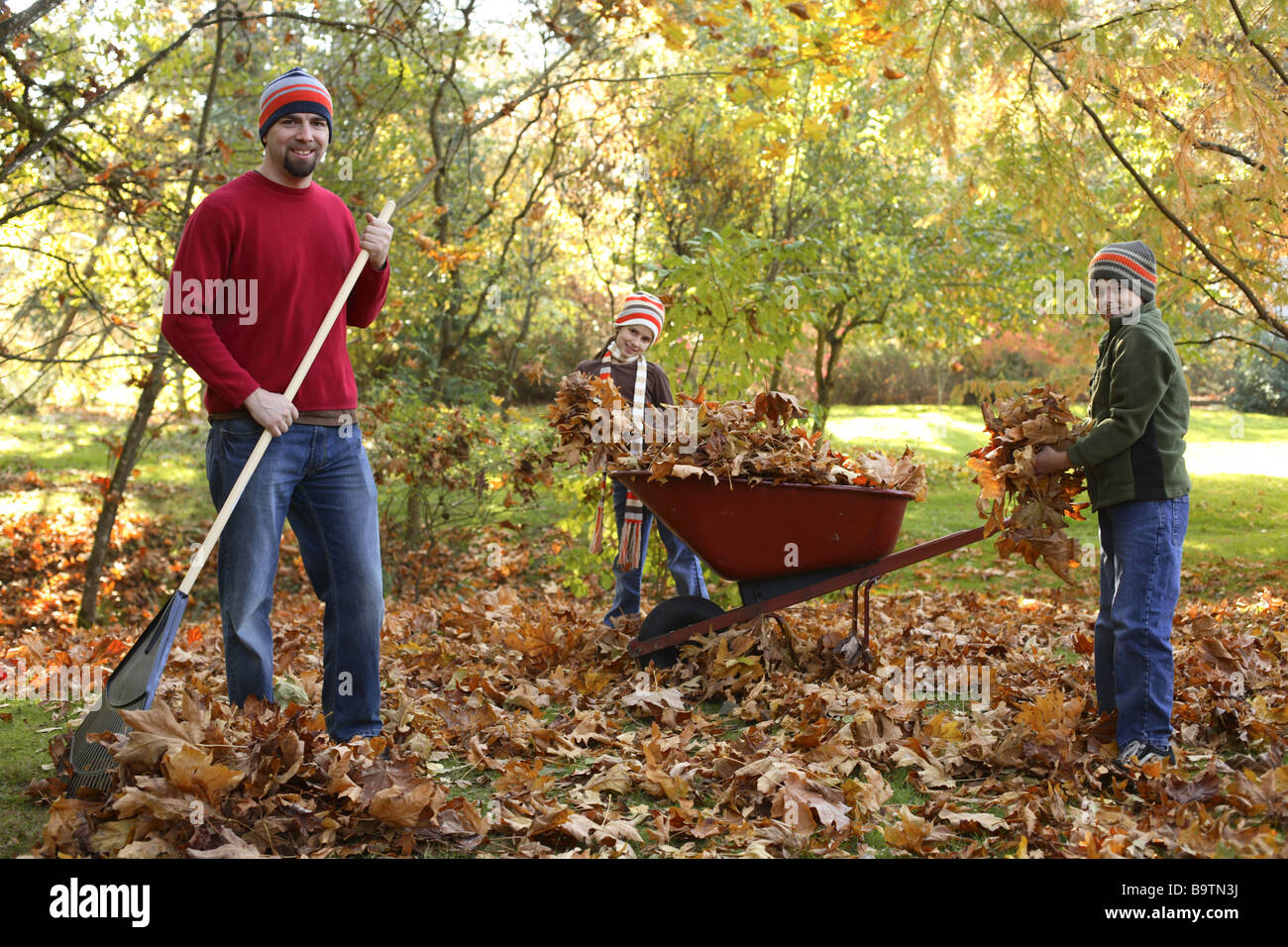Father and children picking up Fall leaves Stock Photo Alamy