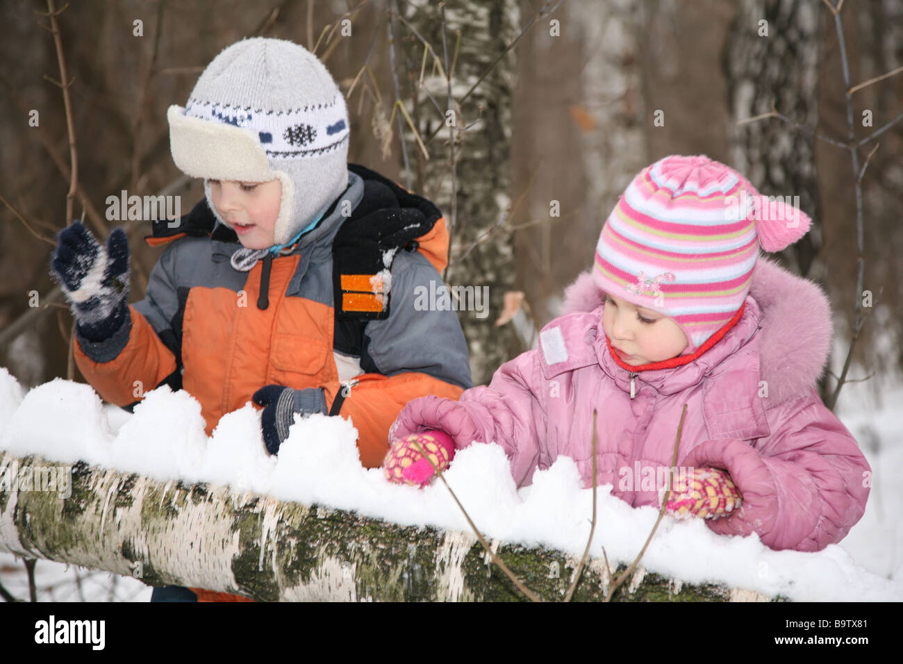 boy and girl paly in forest in winter Stock Photo