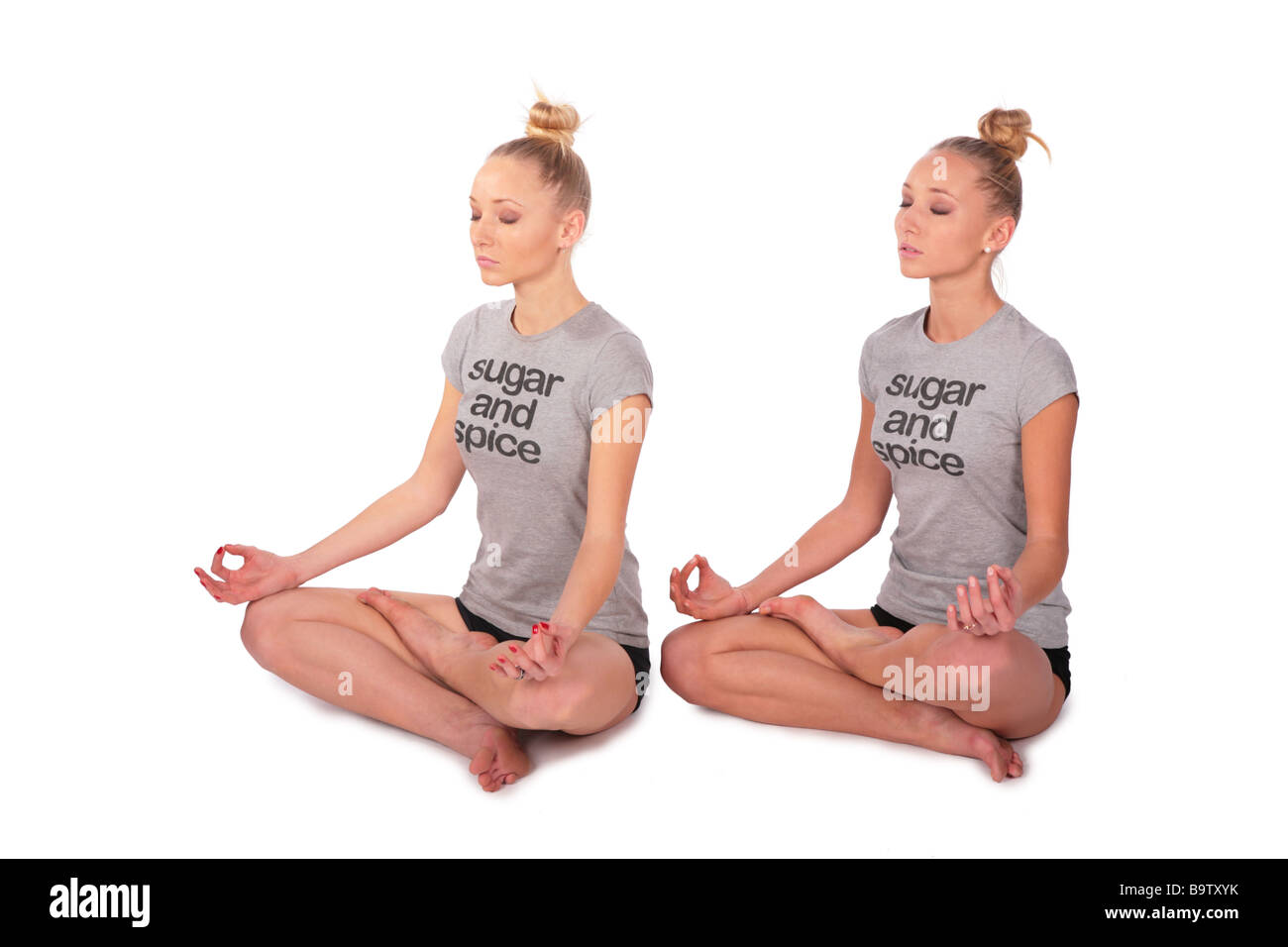 Twin sport girls meditating half-turned Stock Photo
