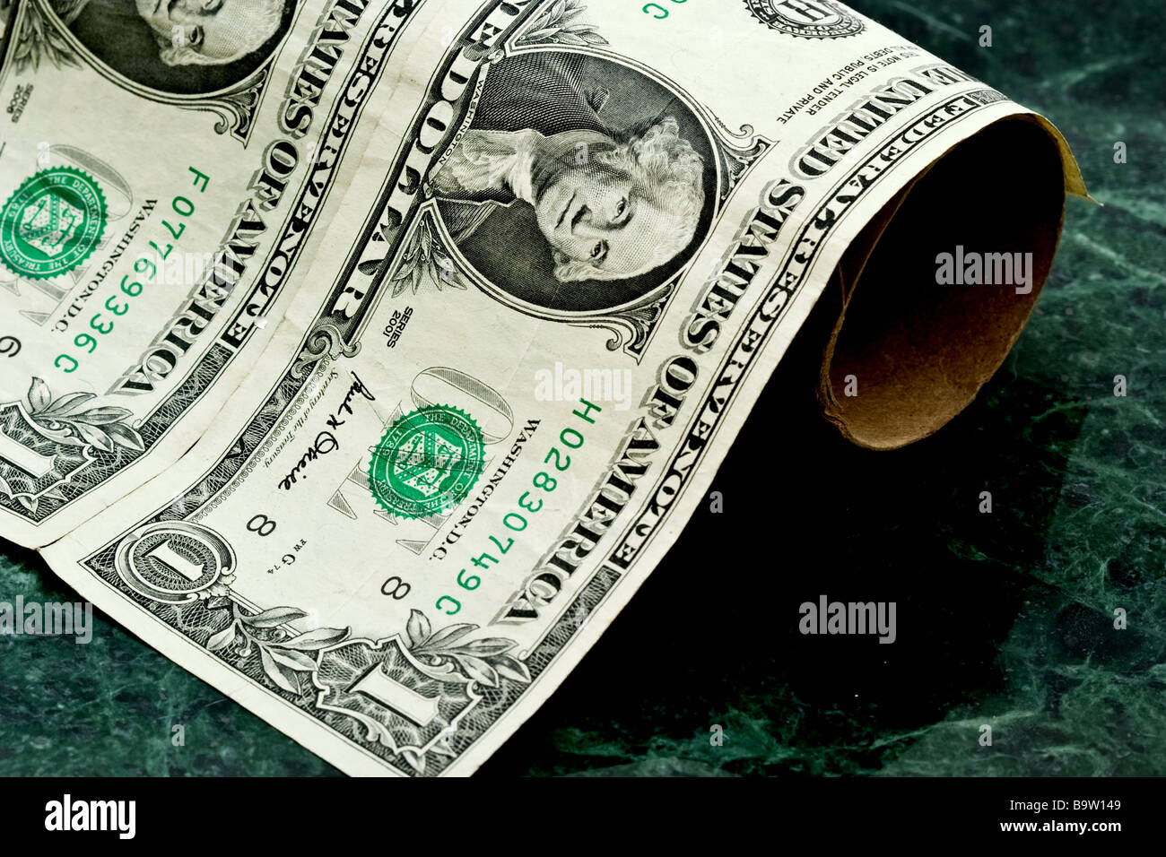 Two American one dollar bills on a cardboard toilet paper roll Stock Photo