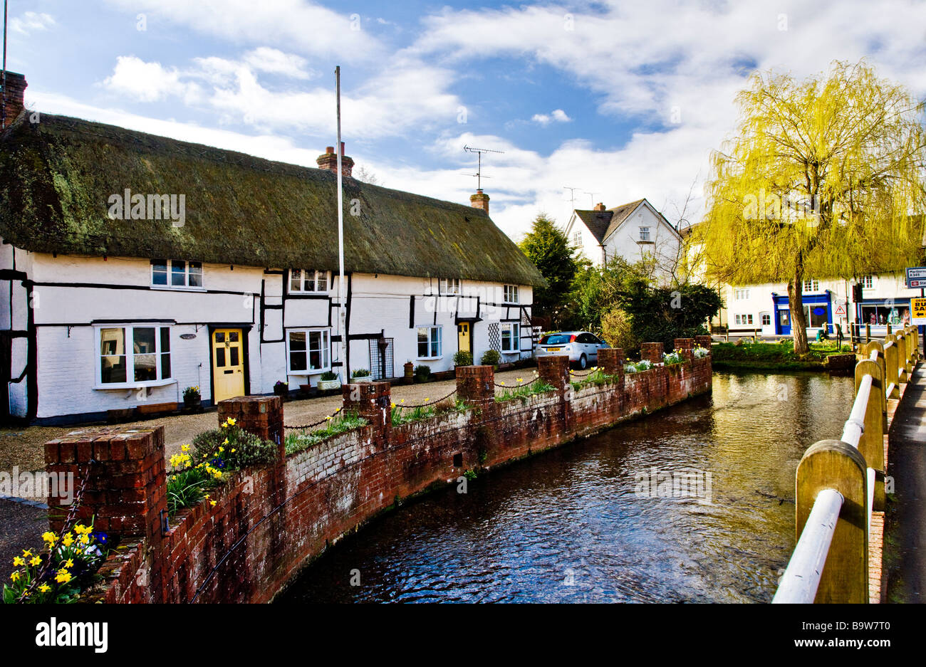 The River Avon flowing alongside a thatched cottage in the village of