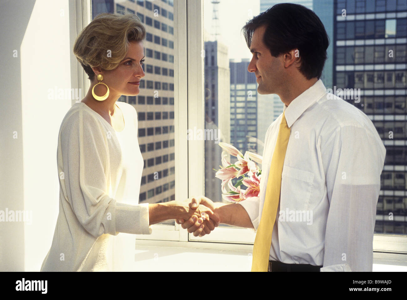 1994 HISTORICAL MAN AND WOMAN OFFICE WORKERS HANDSHAKE Stock Photo