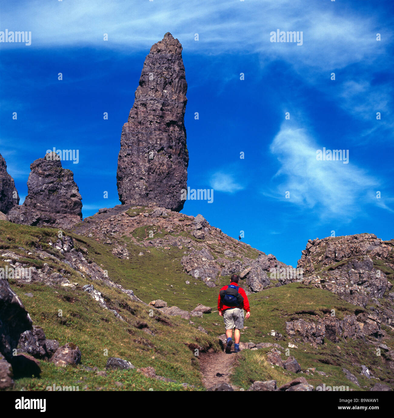 Walker approaching rock pinnacle at The Storr, Trotternish, Isle of Skye, Highland, Scotland Stock Photo