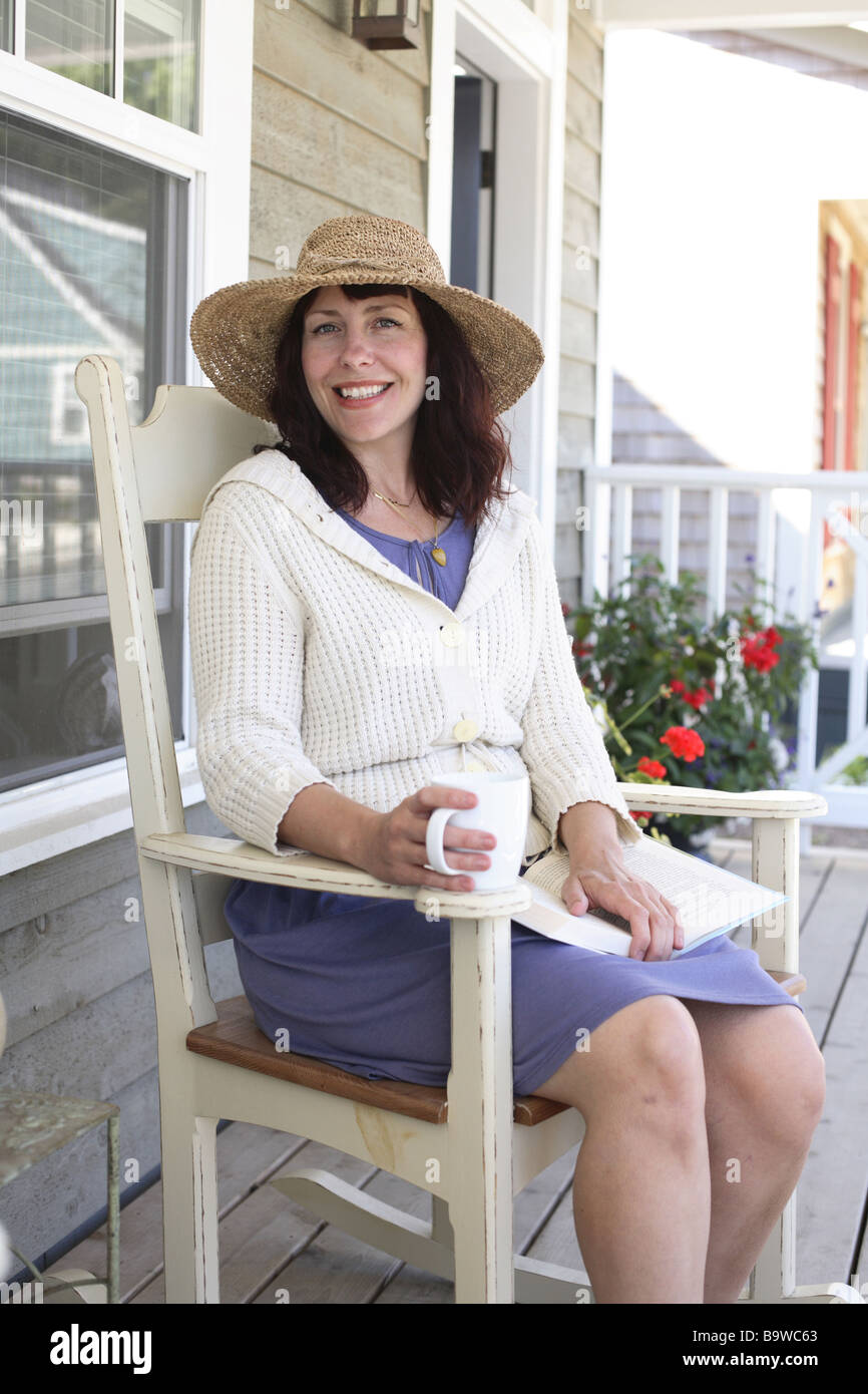 Woman sitting in chair on porch Stock Photo - Alamy