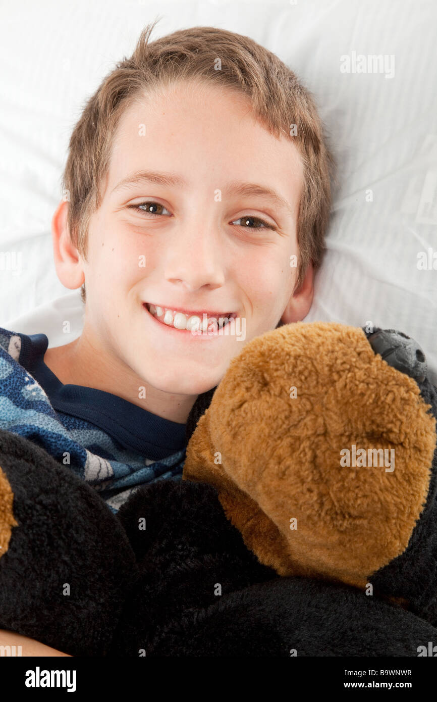 Adorable little boy ready for bed and holding his stuffed animal Stock