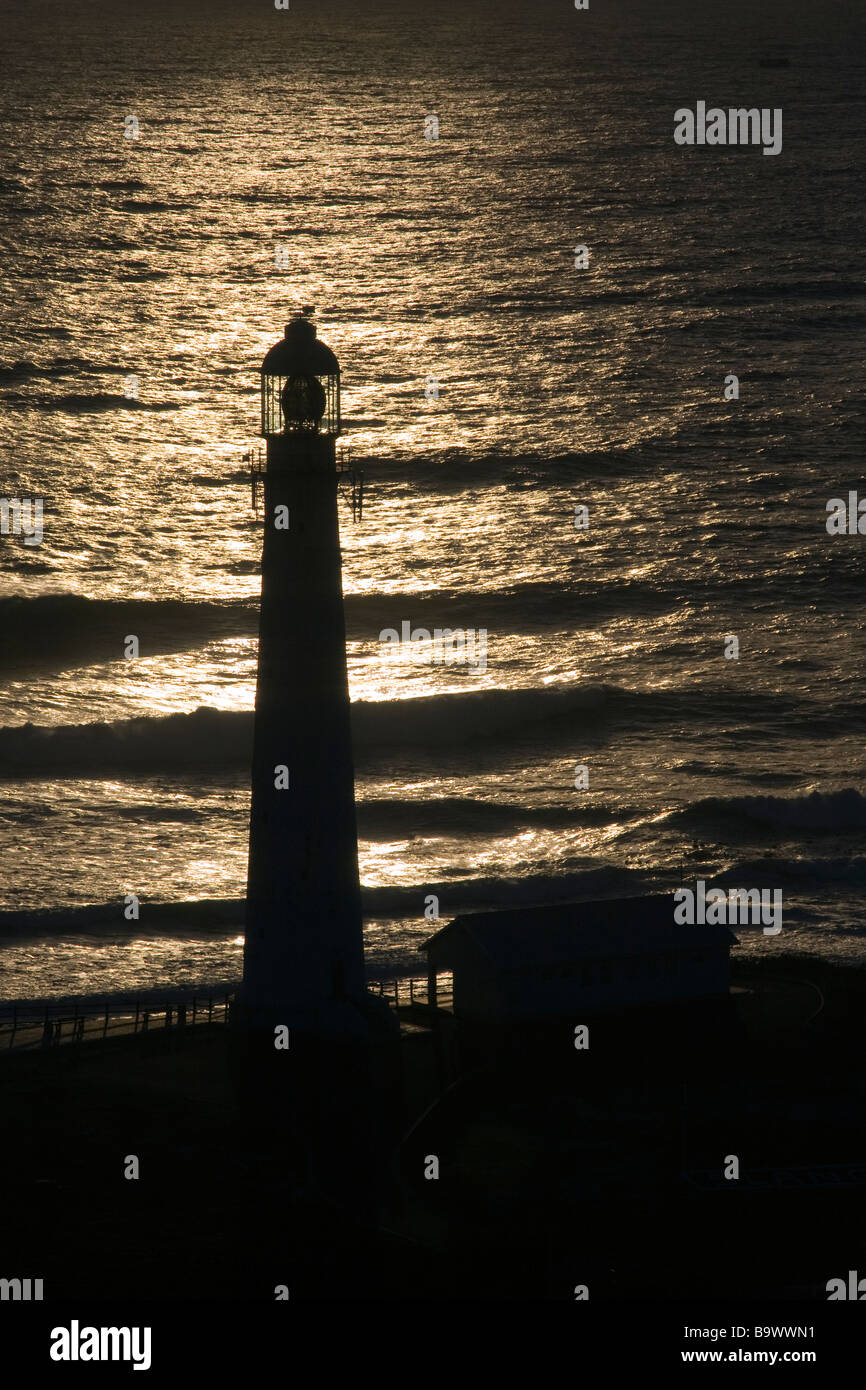 Slangkop Lighthouse Silhouetted against the Ocean at Dusk, Kommetjie Stock Photo