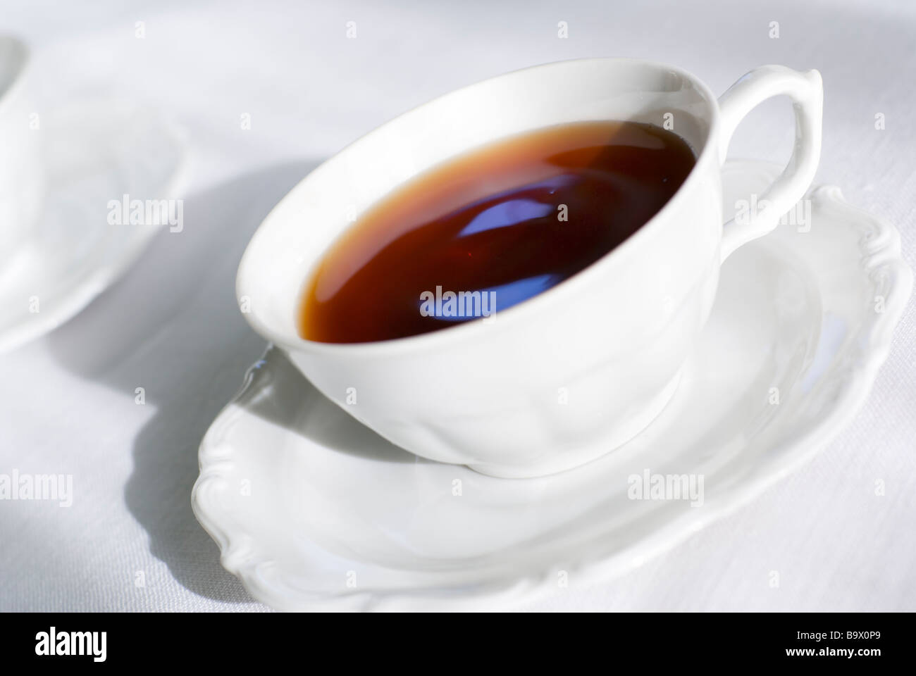 Tea in porcelain teacup. Focus on the cup handle (shallow depth of
