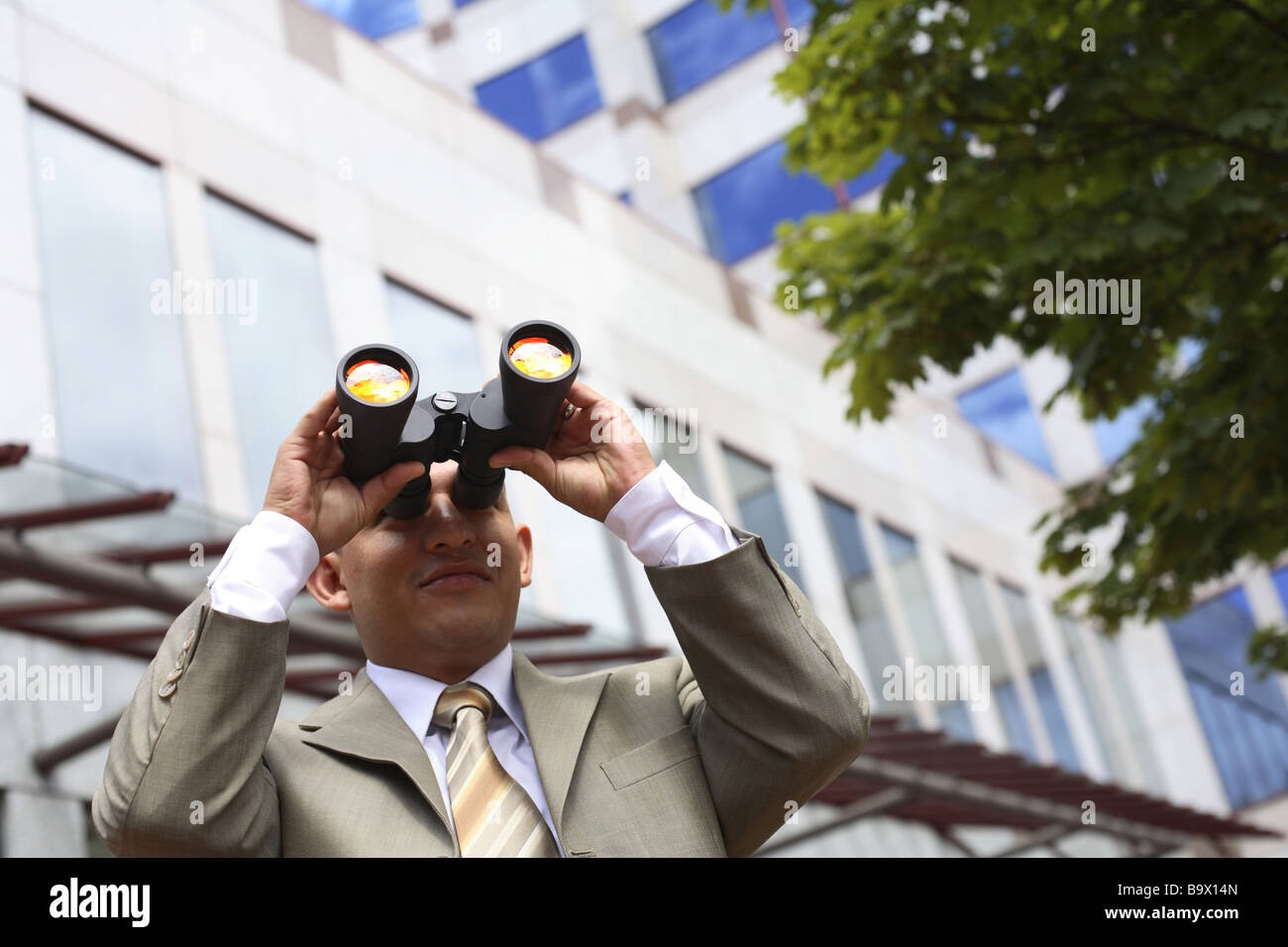 Businessman looking through binoculars Stock Photo